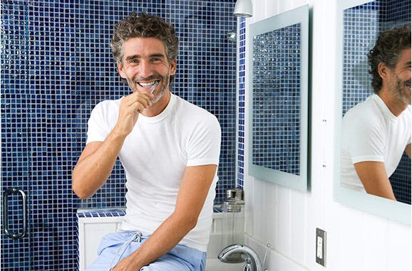 Hombre sonriendo cepillándose los dientes Hombre sonriendo cepillándose los dientes