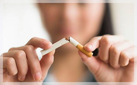 Mujer rompiendo un cigarrillo Mujer rompiendo un cigarrillo