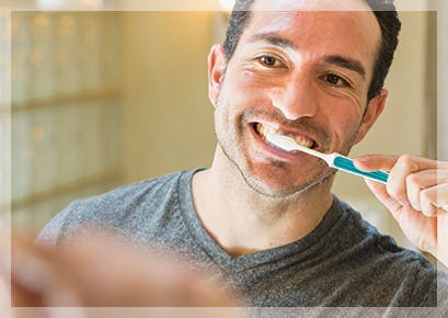 woman looking forward flossing her teeth