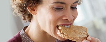 Living with dentures header image Woman eating food