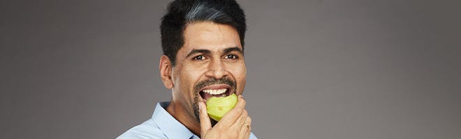 Learning to eat with dentures header image man enjoying difficult to eat food