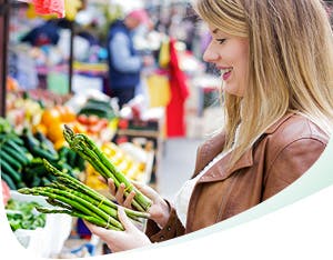 Femme au sourire éclatant qui choisit des légumes Femme au sourire éclatant qui choisit des légumes
