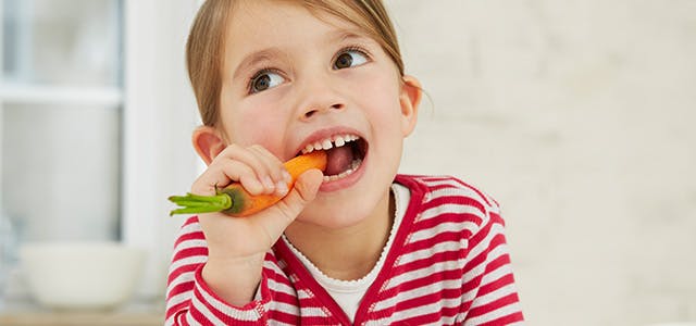 Petite fille croquant une carotte Petite fille croquant une carotte