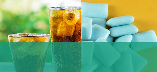 Deux verres de boisson gazeuse acide à côté de gomme sans sucre Deux verres de boisson gazeuse acide à côté de gomme sans sucre