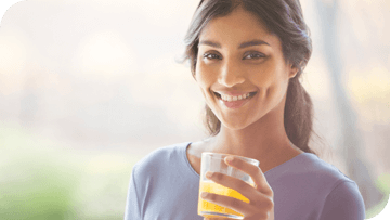 Young girl smiling with a drink in her hands