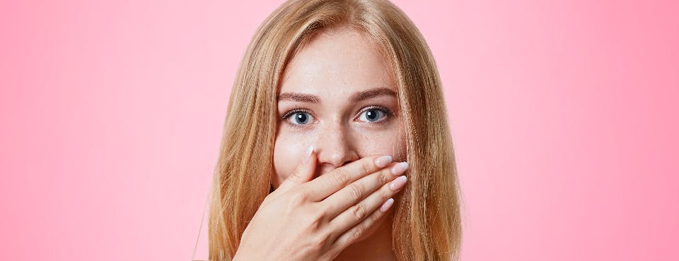 Young woman covering her nose and mouth Young woman covering her nose and mouth