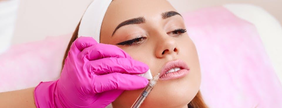 young woman getting lip filler injection young woman getting lip filler injection