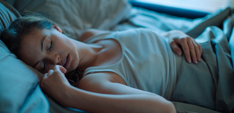 Jeune femme endormie dans son lit Jeune femme endormie dans son lit
