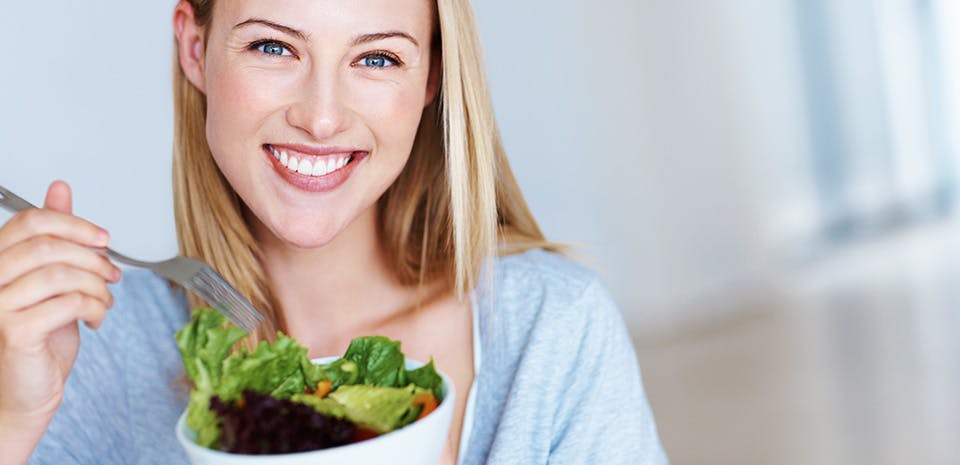 Femme souriante avec une salade | Mangez frais Femme souriante avec une salade | Mangez frais