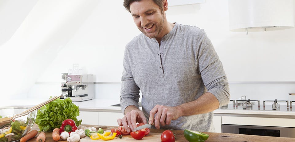 Homme préparant des légumes | Consommez des aliments qui favorisent le sommeil Homme préparant des légumes | Consommez des aliments qui favorisent le sommeil