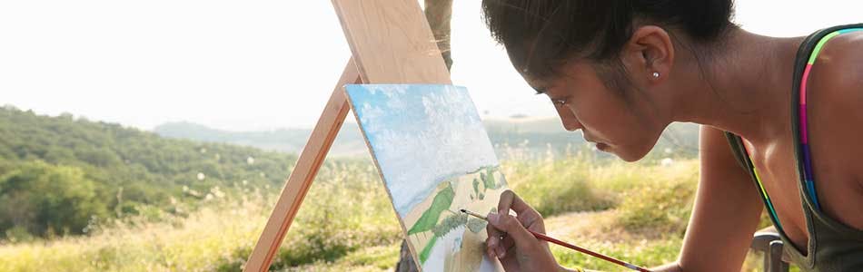 Une femme faisant un croquis de la nature environnante Une femme faisant un croquis de la nature environnante