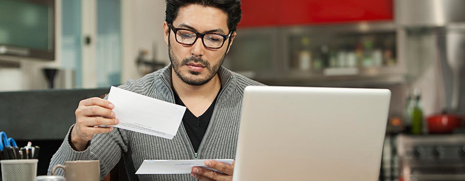 Homme lisant le courrier | Révisez votre budget chaque mois Homme lisant le courrier | Révisez votre budget chaque mois