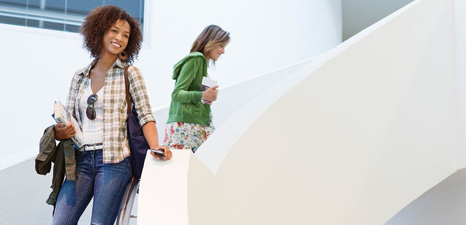 Femme souriante dans un escalier | Allez-y à pied Femme souriante dans un escalier | Allez-y à pied