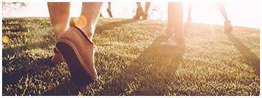 Close up of people’s shoes exercising on a grass field Close up of people’s shoes exercising on a grass field