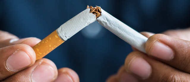 Pair of hands breaking a cigarette in half Pair of hands breaking a cigarette in half