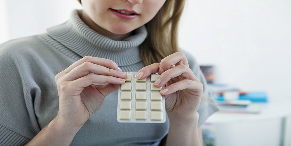 Young woman holding a pack of nicotine gum. Young woman holding a pack of nicotine gum.