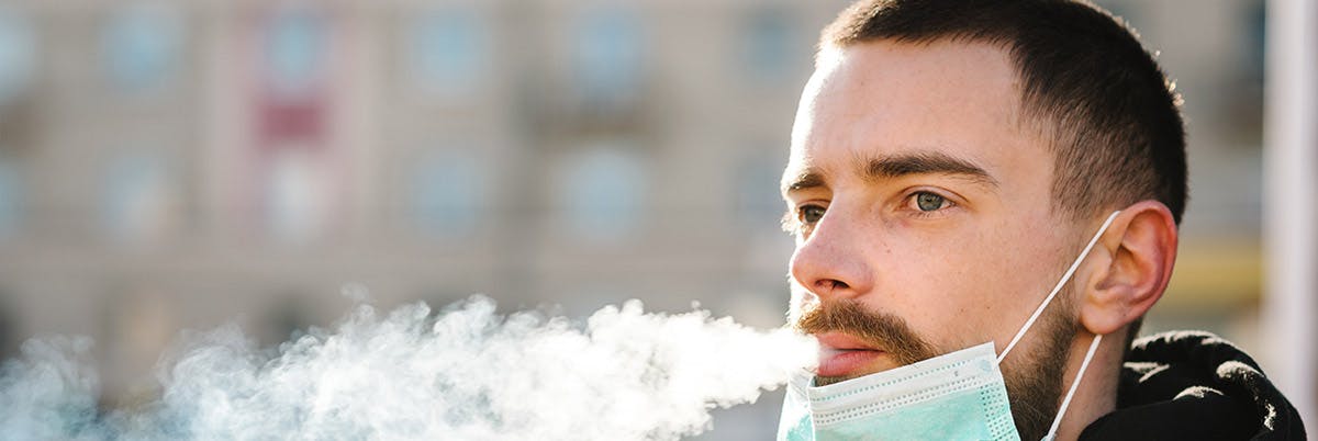 man with mask blowing smoke man with mask blowing smoke